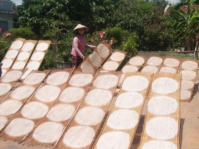 After spreading, the rice papers are carefully sun-dried outdoors to achieve perfect dryness while r...