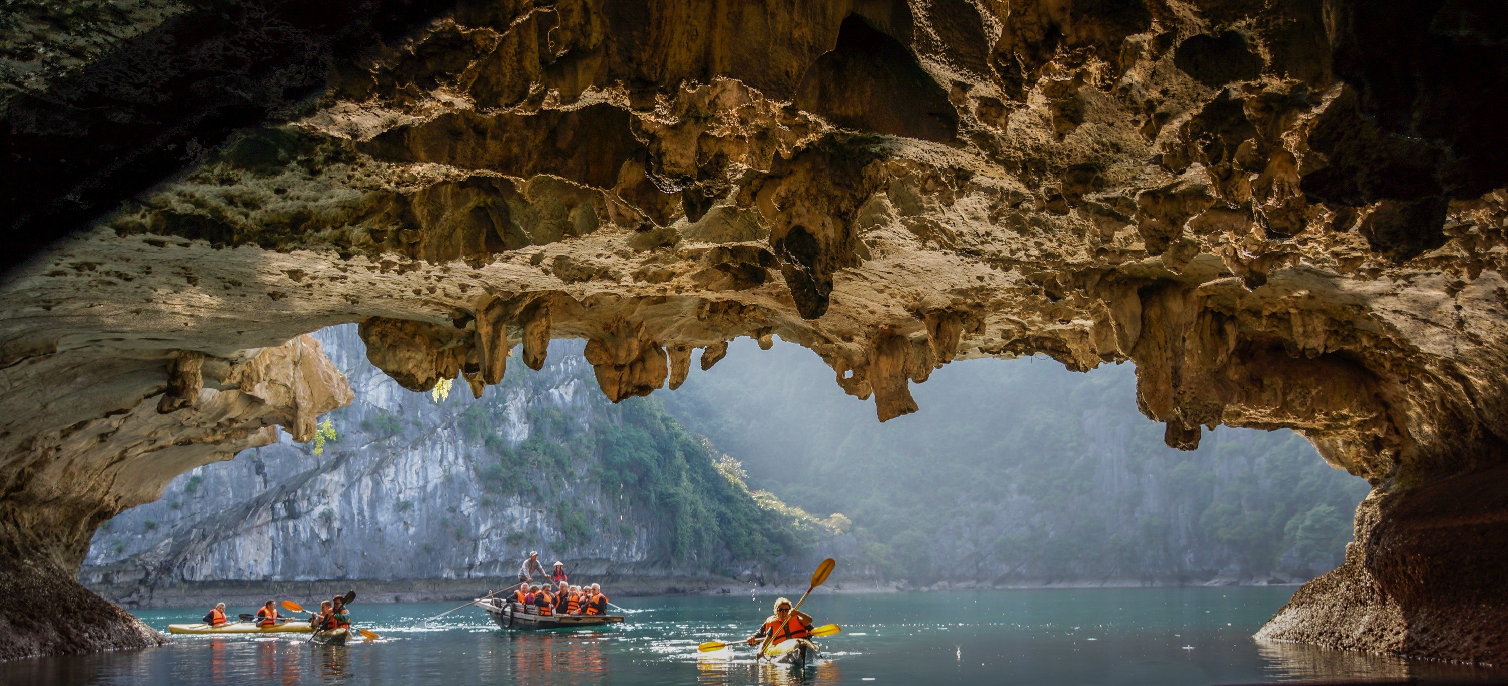 Luon Cave, a low, water-filled tunnel, is a gateway that leads you into a secluded emerald lake nest...